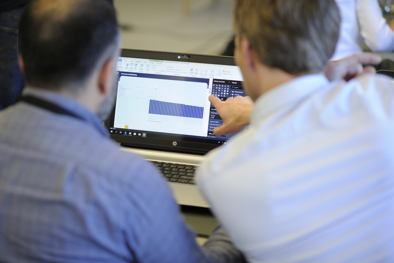 Twee Boostin-adviseurs analyseren samen bedrijfsdata op een laptop